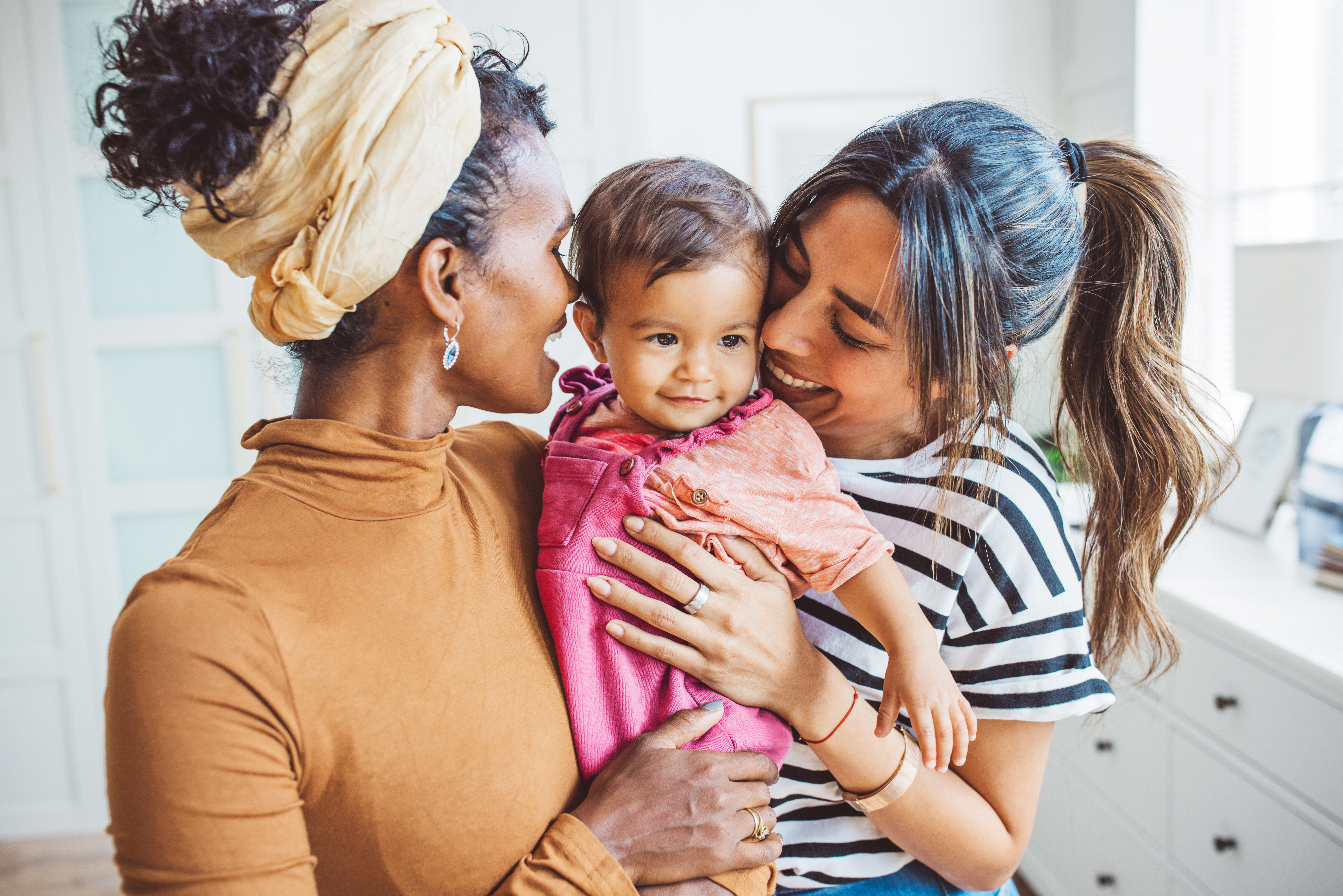Young mothers playing with baby girl in living room