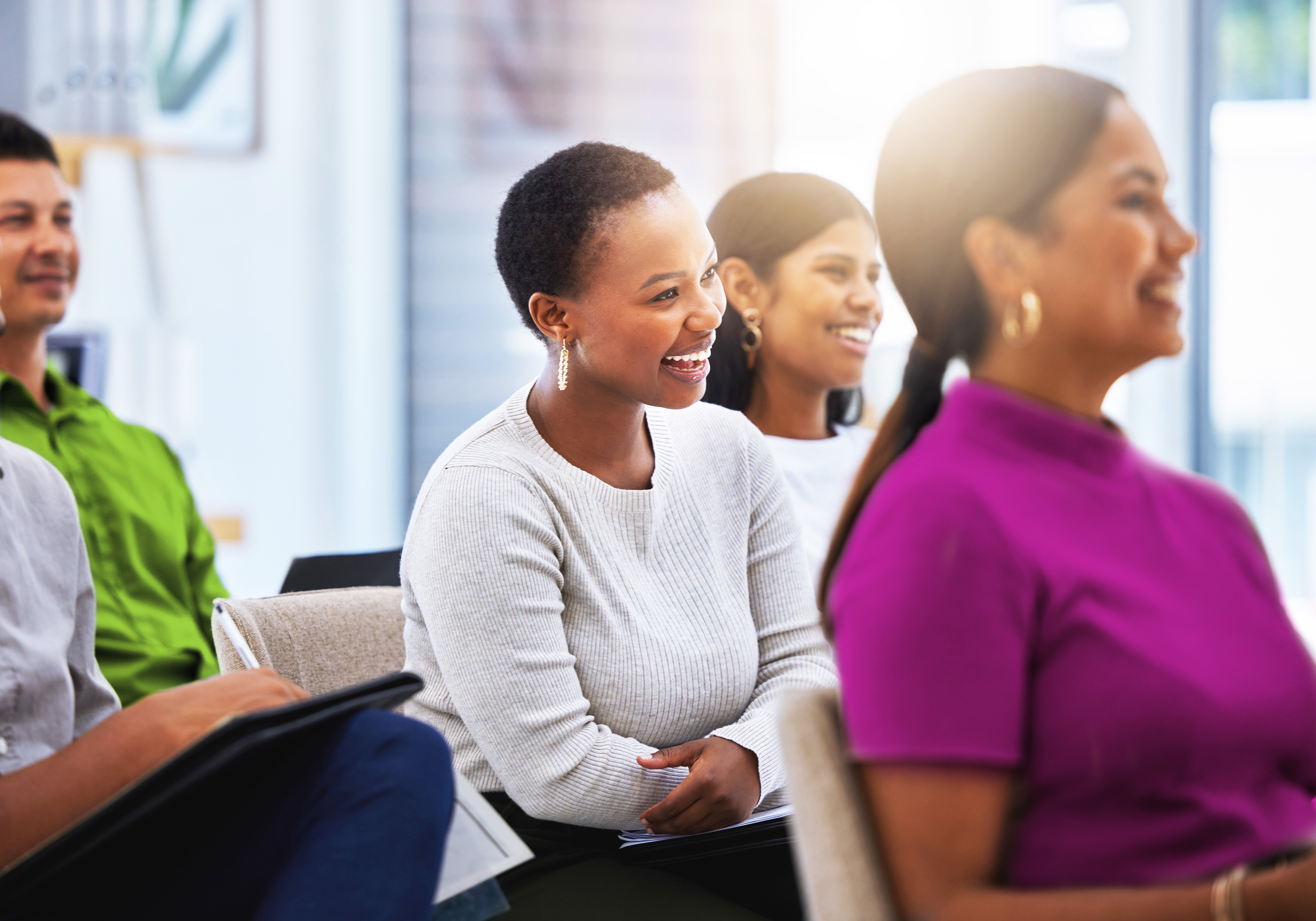Shot of a group of employees laughing during a meeting at work in a modern office